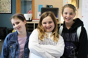 Girls smiling by board